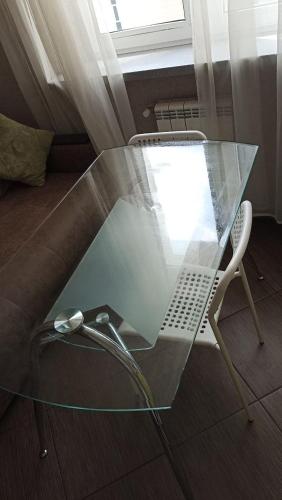 uma mesa de vidro e uma cadeira num quarto em New vip 287 em Tbilisi
