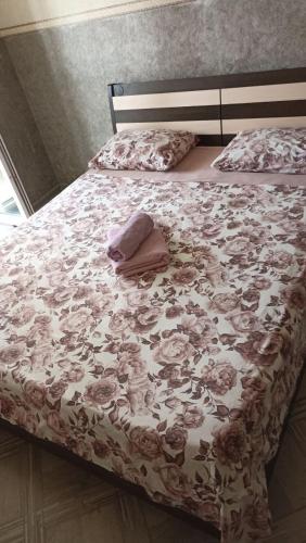 uma cama com uma colcha floral com uma toalha em New vip 287 em Tbilisi