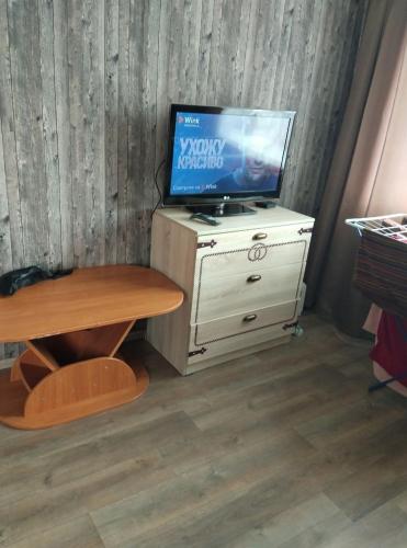 uma televisão em cima de um armário com uma mesa em New vip 287 em Tbilisi