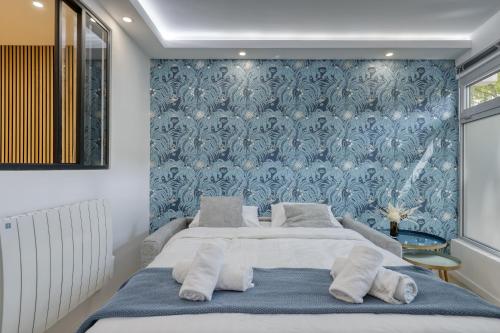 une chambre avec deux lits et un mur bleu dans l'établissement Stylish & New 1 Bdr Flat with A/C-Trendy Paris 11, à Paris