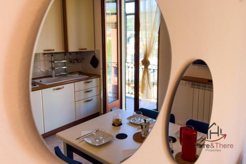 a room with a table and a kitchen with a mirror at [Varazze Center] Free Parking • WiFi • Disney+ in Varazze