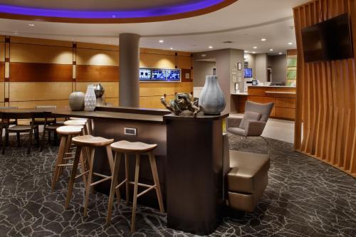 a lobby with a bar with stools and a table at SpringHill Suites Savannah Airport in Savannah