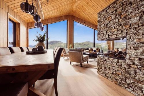 a living room with a stone wall and a table and chairs at The View - Hodlekve in Sogndal