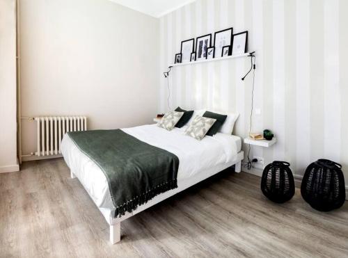 - une chambre avec un lit blanc et une couverture verte dans l'établissement Charmant appartement - Chambre séparée - 300m de la gare et accès direct au cœur historique, à Poitiers