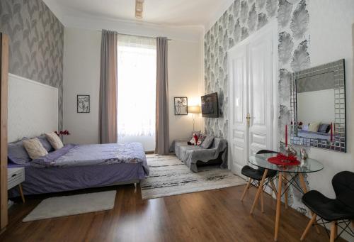 1 dormitorio con cama, mesa y espejo en Casa Larisa, en Arad