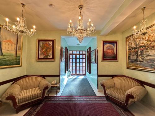 a hallway with two chairs and a chandelier at Beatrix Lux Hotel in Budva