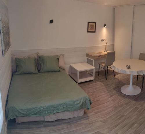 um quarto com uma cama, uma secretária e uma mesa em STUDIO CALME PROCHE CENTRE BORDEAUX em Bordeaux