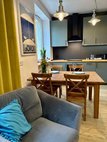 a living room with a couch and a table and a kitchen at Jazz Apartament Częstochowa Centrum 2-bedroom in Częstochowa
