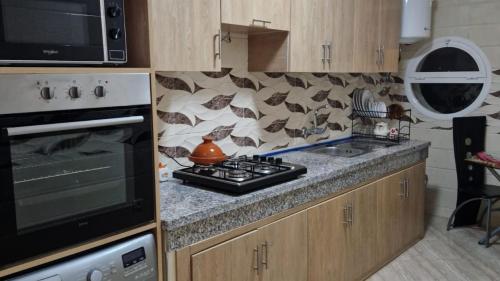 uma cozinha com fogão forno ao lado de um micro-ondas em Elégant appartement Chez Yalah em Temara