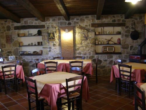a restaurant with tables and chairs in a room with stone walls at B&B Le Grazie in Piaggine