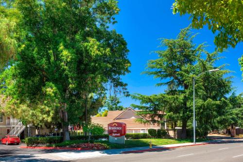 uma rua com uma placa de coca cola em frente a uma casa em Residence Inn San Jose Campbell em Campbell