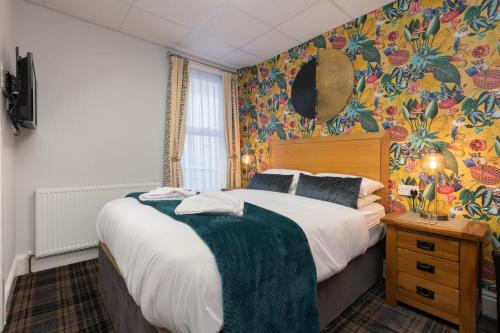 um quarto com uma cama e um papel de parede florido em Adelaide Lodge - Town Centre - Opposite Winter Gardens em Blackpool