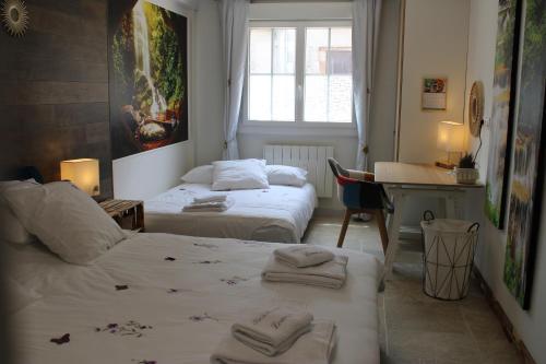 een slaapkamer met 2 bedden en een bureau bij Résidence Loanie & Soins in Châlus