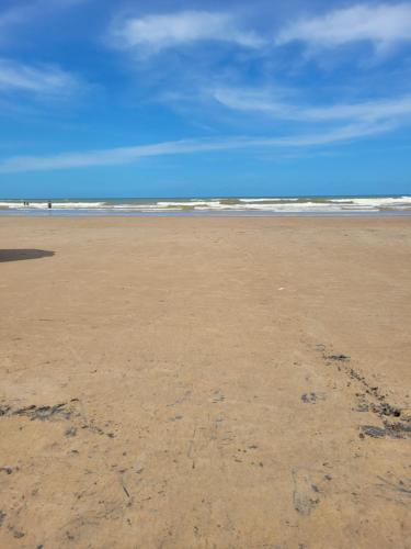 an empty beach with footprints in the sand at Casa Praia 1000 - Guriri Norte in São Mateus