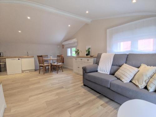 sala de estar con sofá gris y cocina en Apartamentos Baldenora en Llanes