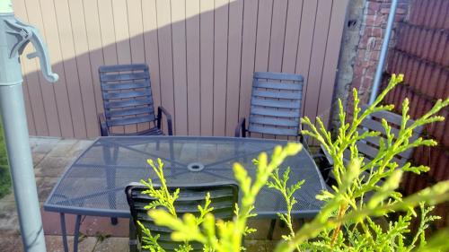 two chairs and a glass table in front of a building at Ferienwohnung Villmar in Villmar