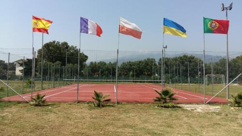 a tennis court with four flags on it at Camping Ulisse Calabria in Lamezia Terme