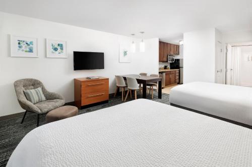 a hotel room with two beds and a table and chair at TownePlace Suites by Marriott Roswell in Roswell