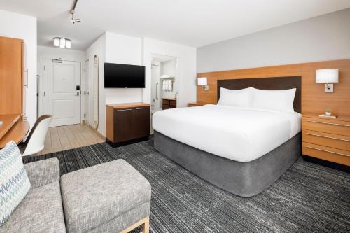 a hotel room with a large bed and a couch at TownePlace Suites by Marriott Roswell in Roswell