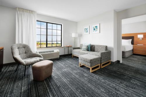 a hotel room with a bed and a chair and a couch at TownePlace Suites by Marriott Roswell in Roswell