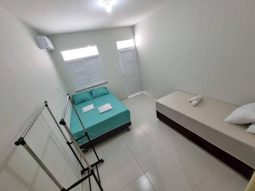 a small room with two beds and a window at Casa 2/4 para temporada in Aracaju