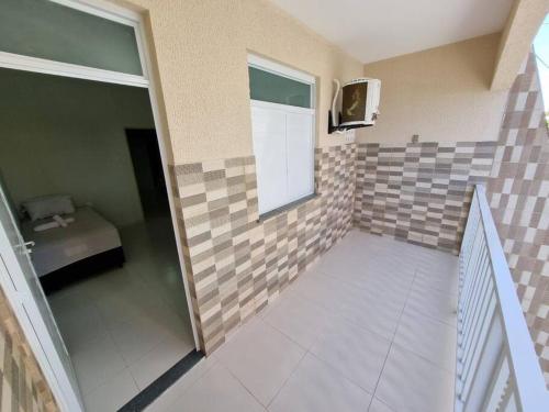 a small bathroom with tiles on the wall at Casa 2/4 para temporada in Aracaju