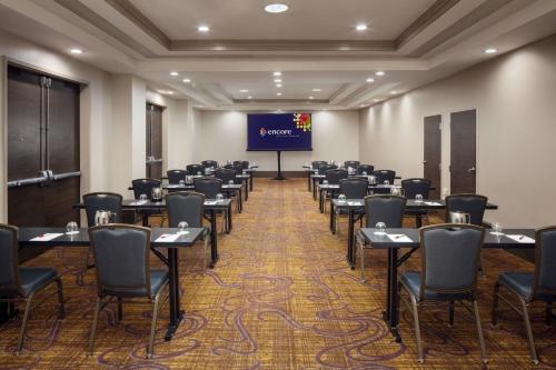 a conference room with tables and chairs and a screen at Marriott Savannah Riverfront in Savannah