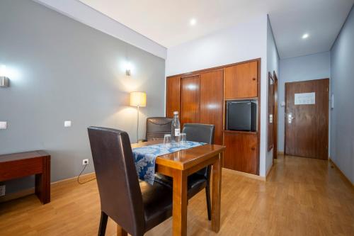 a dining room with a table and chairs and a television at Hotel Onix in Viseu