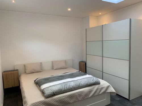ein Schlafzimmer mit einem Bett und einem großen weißen Schrank in der Unterkunft Schlafzimmer Nr1 Heidingsfeld Würzburg in Würzburg