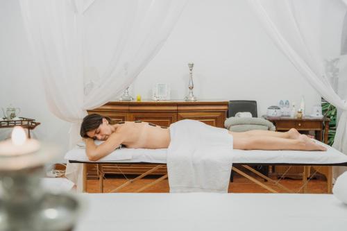 a woman laying on a bed in a room at Hotel Onix in Viseu