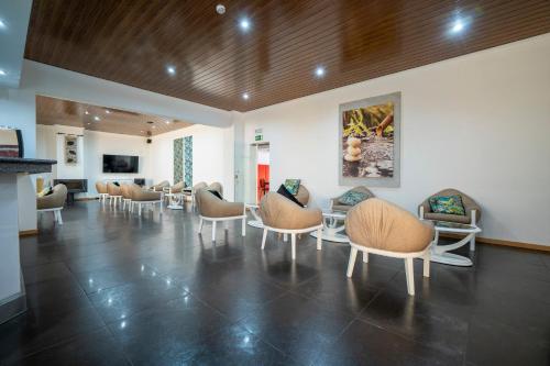 uma sala de espera com cadeiras e mesas num edifício em Hotel Onix em Viseu