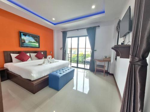 1 dormitorio con paredes de color naranja, 1 cama y TV en Lanta noblesse, en Ko Lanta