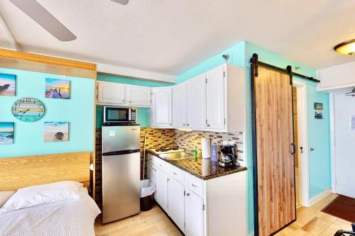 a kitchen with white cabinets and a refrigerator at Daytona Beach Club 708 in Daytona Beach
