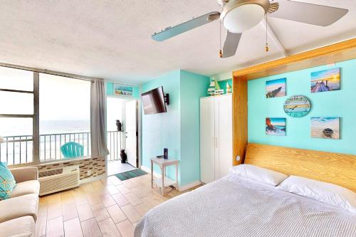 a bedroom with blue walls and a bed and a couch at Daytona Beach Club 708 in Daytona Beach