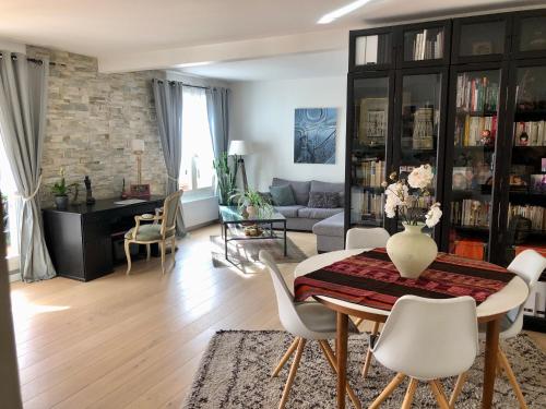 sala de estar con mesa y sillas en Le Fontenay bleu, en Bourg-la-Reine