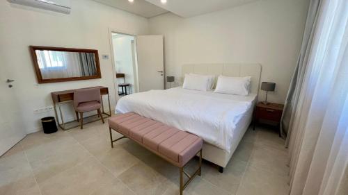 a bedroom with a large white bed and a table at Sunraf Luxe Apartments in Budva