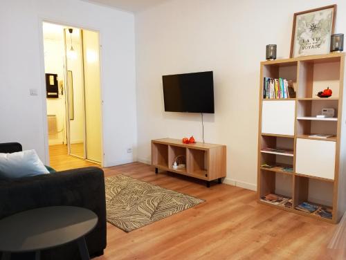 sala de estar con sofá y TV en Le Cyprès - Charmant, Agréable et Tout Confort en Béziers