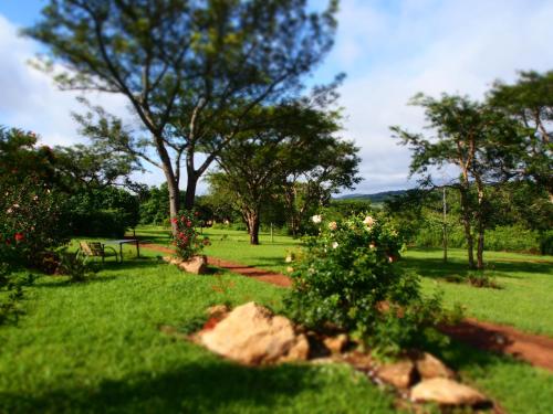 a park with a bench and flowers in the grass at Thokozani Lodge in White River