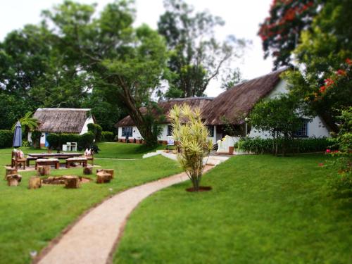 a garden with a picnic table and a house at Thokozani Lodge in White River