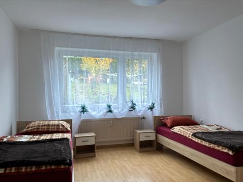 1 dormitorio con 2 camas y ventana en Ferienwohnung Grimm, en Pforzheim
