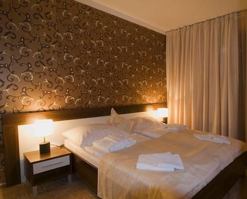 a bedroom with a large bed with two towels on it at Penzión Villa in Rajecké Teplice