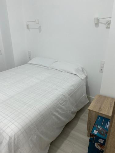 a bedroom with a white bed and a wooden table at Moncloa apartment, con parking in Madrid