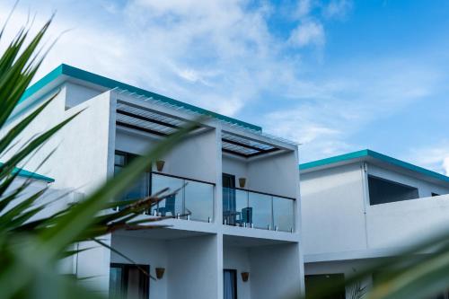 a white building with a blue roof at Le Marin, Rodrigues Island in Rodrigues Island