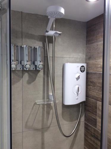 a shower with a shower head in a bathroom at Birch Tree House in Windermere