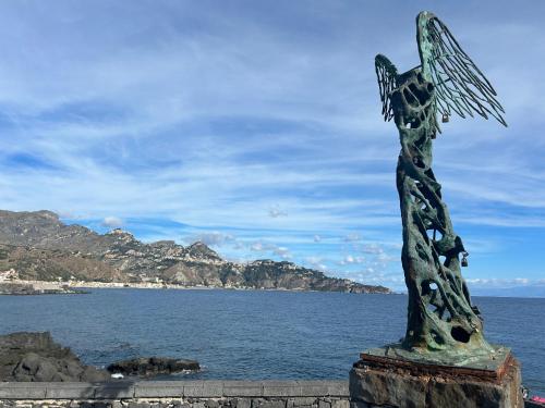 a statue of a person with a fish in the ocean at SummerHouse in Mazzeo
