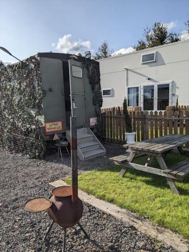 a rv parked in a yard next to a table at Military Shepherd Hut in Haxey