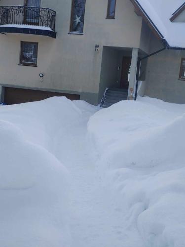 a pile of snow in front of a house at U Chowańców in Bańska Niżna