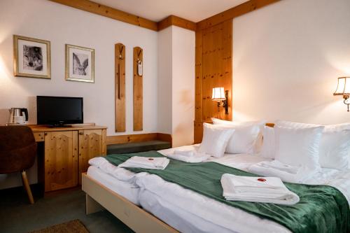 a hotel room with a bed with towels on it at Hotel zum See, Titisee in Titisee-Neustadt