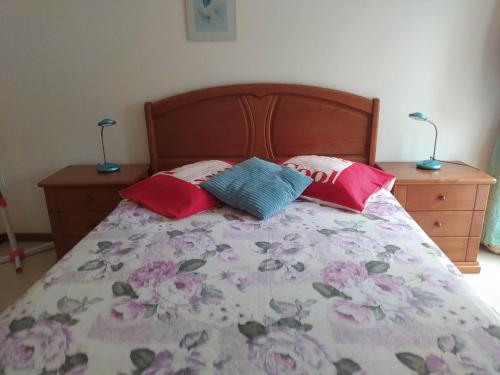 a bed with two pillows on it with two night stands at Laginha Beachview in Mindelo