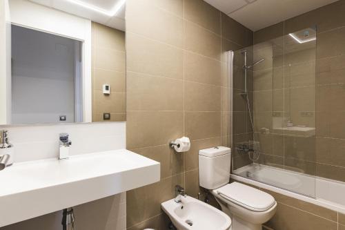 uma casa de banho com um WC, um lavatório e um chuveiro em Intempo Residential Sky Resort & Spa - Benidorm, España em Benidorm